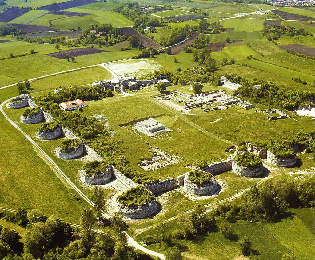 圖片呈現了塞爾維亞加姆濟格勒古遺址，遺址內佈滿了古羅馬時期的建築結構，周圍綠草如茵，展現了歷史與自然的和諧結合。